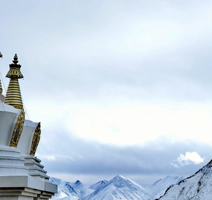 Stupas at Drak Yerpa framed by majestic snow-covered mountains, creating a serene and spiritual Tibetan landscape.